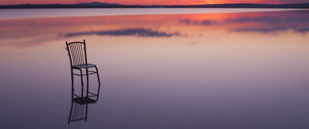 chair on a lake at sunset