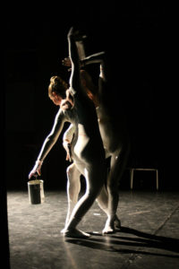 Auf der Bühne bewegen sich zwei Tänzer und bemalen sich mit Farbe an. Sie sind wie eine Leinwand. Viele Bewegungsbilder entstehen und jedes ist anders.